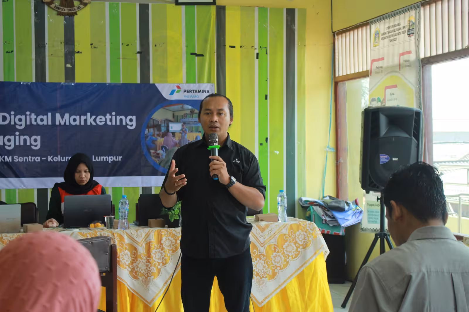 Siswa berkolaborasi di sekitar laptop di ruang kelas