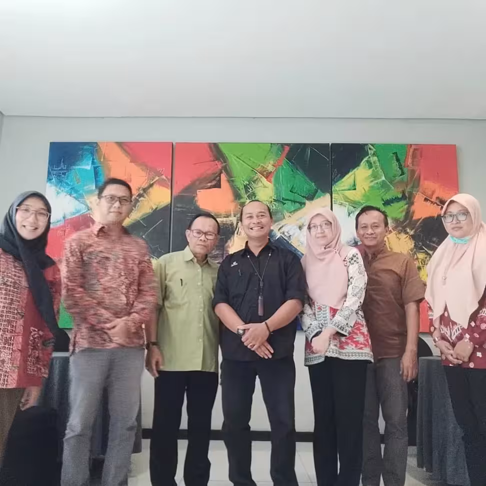 Mentor UTBEX duduk bersama kelompok kecil pengusaha desa, berdiskusi bersama dengan pencahayaan alami.