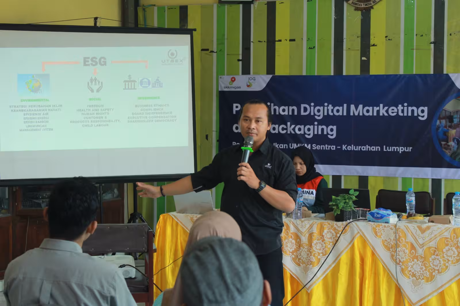 Seorang perajin dengan hati-hati menggambar pola batik di atas kain